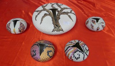 a group of painted rocks sitting on a red cloth