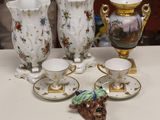 cinq tasses et soucoupes posées sur une table, avec une figurine de chien