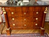 une commode en bois avec un plateau en marbre dans une chambre