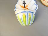 un petit vase orné d'une croix, posé sur une table