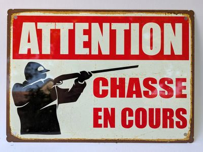un panneau indiquant « Attention, chasse en cours »