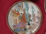 quatre assiettes ornées de motifs asiatiques posées sur une table rouge