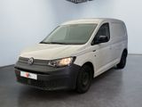 La camionnette blanche est garée dans une grande pièce au sol noir.