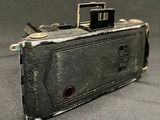 an old camera sitting on a table with a black background