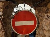 a red and white sign hanging from a brick wall