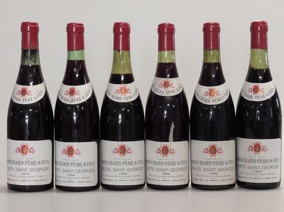 six bottles of wine are lined up in a row on a table
