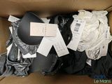 une boîte en carton remplie de nombreux vêtements et d'un chapeau