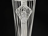 a white wire sculpture of a vase on a stand