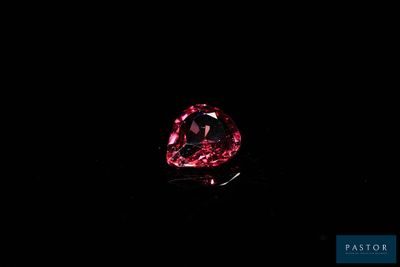 a close up of a red diamond on a black background
