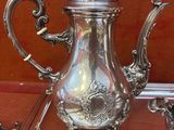 une théière en argent posée sur une table en verre