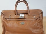 un sac à main en cuir marron posé sur une table en bois
