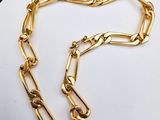 a gold chain on a white plate with a black background