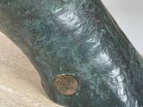 bronze statue of a woman ' s foot on a marble slab