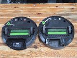 two vacuum cleaners sitting on top of a wooden table next to each other