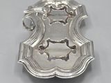 a silver plate with a design on it on a table