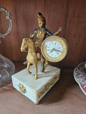 une statue représentant un homme à cheval, sur laquelle est placée une horloge