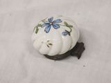 a small white knob with blue flowers on it