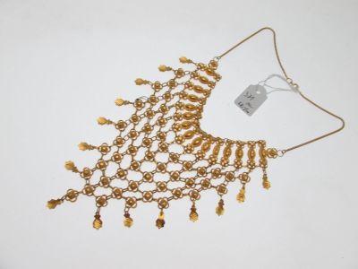 gros plan d'un collier en or sur fond blanc