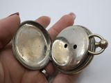 someone is holding a silver pocket watch in their hand