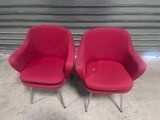 pair of red chairs with chrome legs in front of a garage door