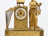une horloge en or représentant une femme tenant une harpe
