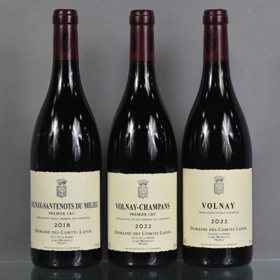 three bottles of red wine are lined up on a table