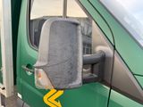 an image of a side view mirror of a green van