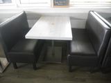 a table and two chairs in the corner of a booth