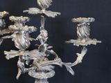a silver candelab with birds on it on a black background