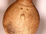 a brown vase that is sitting on a white surface