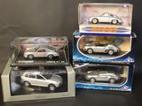 three toy cars are sitting in boxes on a black surface