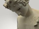 statue of a young boy holding a bird in his hand