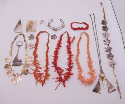 Plusieurs colliers et bracelets sont exposés sur un fond blanc