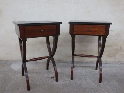 two wooden tables with black tops on them