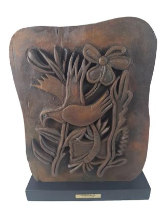 sculpture of a bird and flowers on a stone block