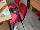 two red chairs in the corner of a room next to a desk with a computer on it