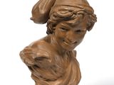 an antique bronze bust of a woman with a hat on her head