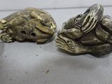 three silver figurines of monkeys sitting on a table