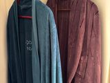 two coats hanging on the wall next to each other
