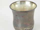 a small metal cup sitting on a white surface