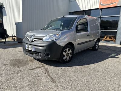 La camionnette argentée est garée devant un immeuble.