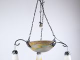 un lustre composé de trois abat-jours en verre suspendus à une chaîne