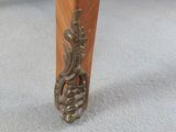 the legs of a wooden table with a metal handle on it
