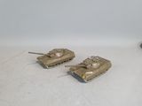 two toy tanks sitting next to each other on a white surface