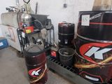 Plusieurs bidons d'huile moteur sont empilés sur un rayonnage dans un garage