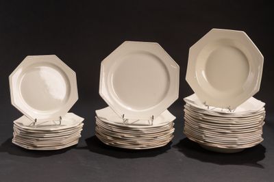 plusieurs assiettes blanches empilées les unes sur les autres sur une surface noire