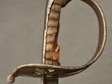 an old sword with a metal handle on a gray surface