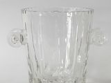 a clear glass vase with a handle on a table