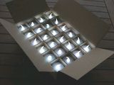 a box of lit candles sitting on a wooden table