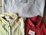 Trois chemises pour homme et un t-shirt sont posés sur une boîte en carton